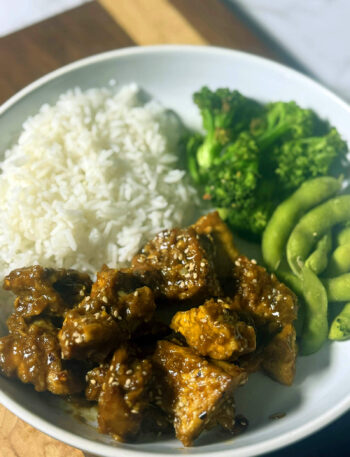 Crispy orange tofu bowl with edamame rice, broccoli and sesame seeds
